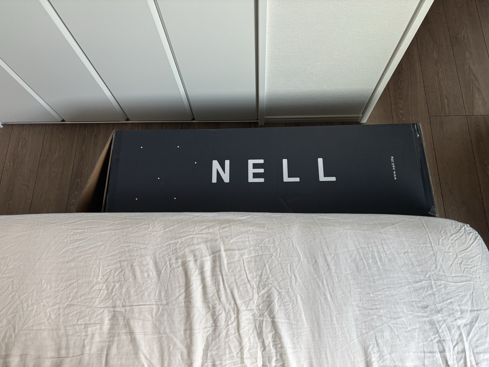 ベッド横に横置きしたNELLマットレスの配送用段ボール箱