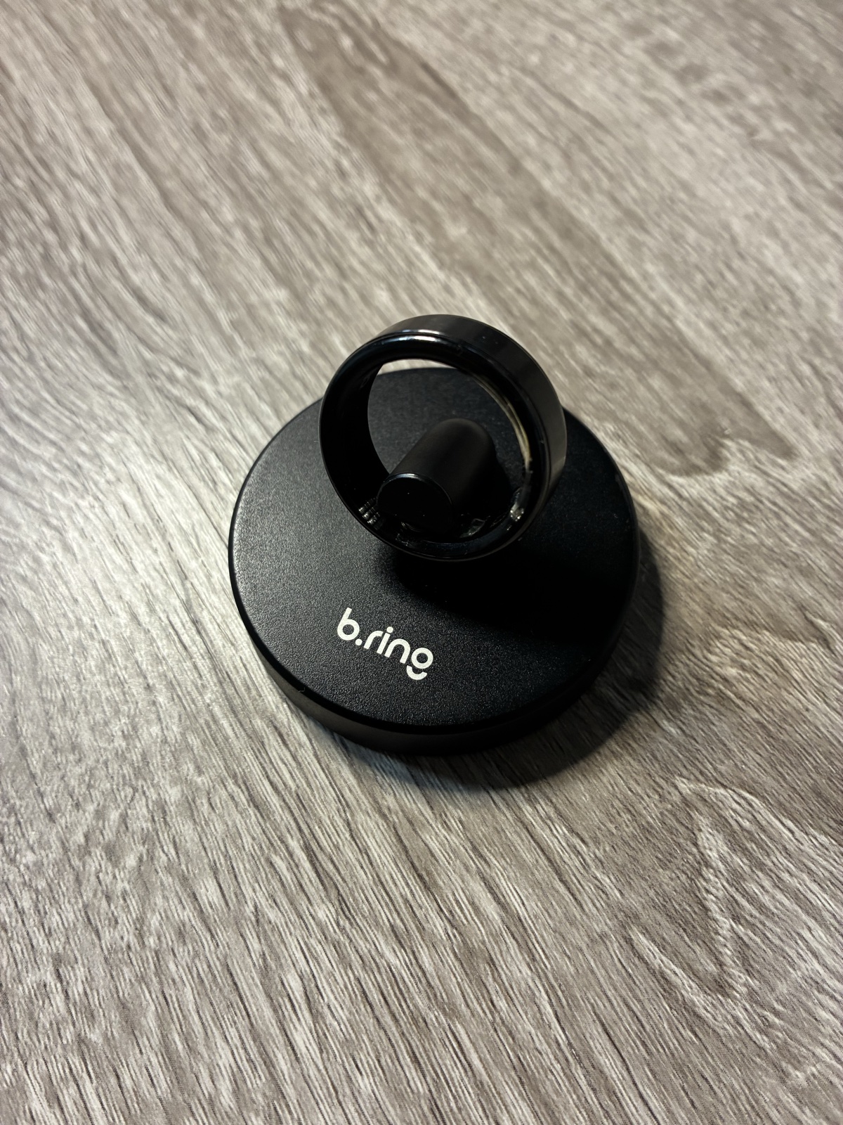 自宅で別売の置き型充電スタンドに載せたブラックのb.ring G2